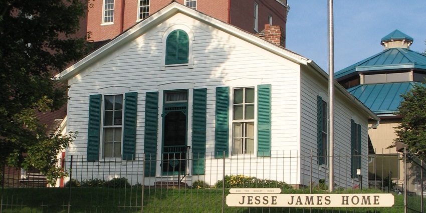 Jesse James home museum with white, green building, multiple windows and a signage