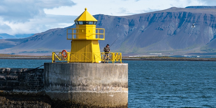 A breathtaking view of a lighthouse situated beside a stunning water body on a perfect day.