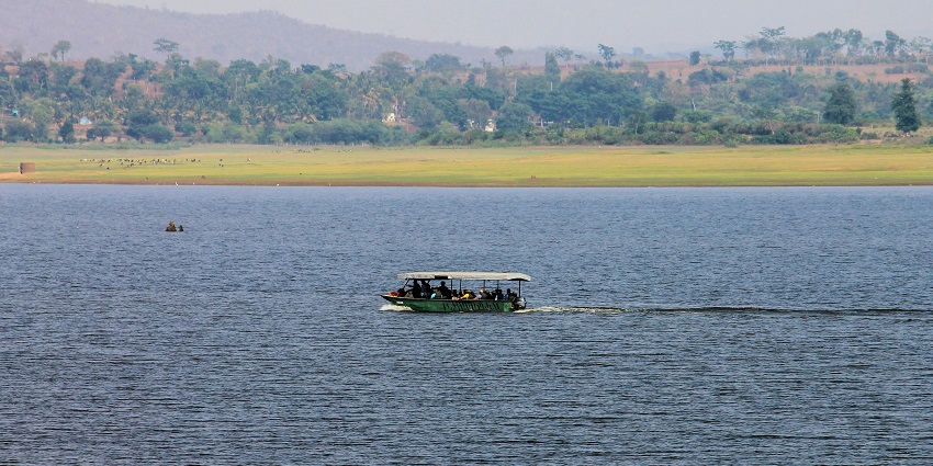 Serene view of Kabini River flowing through lush green forested landscape.