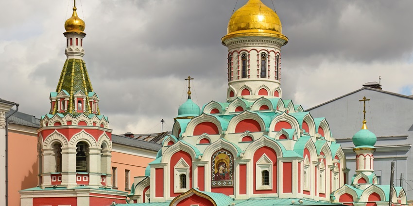 Kazan Cathedral, illuminated at sunset during winter, with a decorated Christmas tree.
