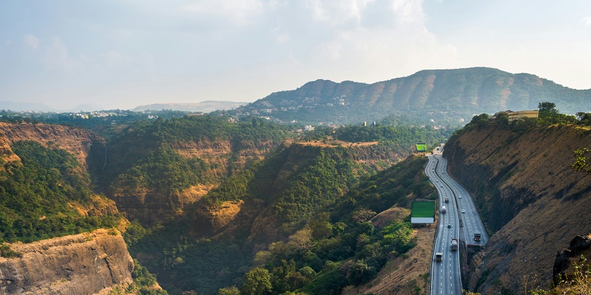 Winding highway through lush green hills near Pune, offering scenic summer place.