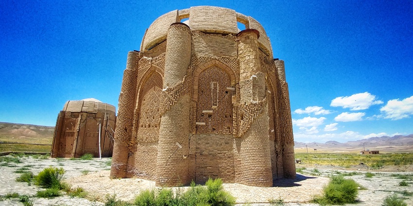 Seljuk-style brickwork and domed structure of the Kharraqan Towers in the quiet landscape.