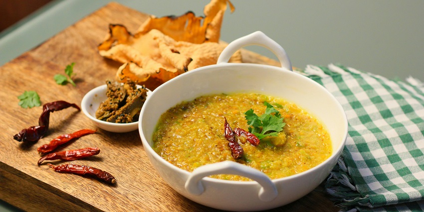 Traditional Bengali khichuri served with fried vegetables and papad on a plate