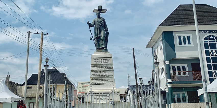 A grey statue of King Jaja of Opobo, depicting the historic Nigerian ruler in regal attire.