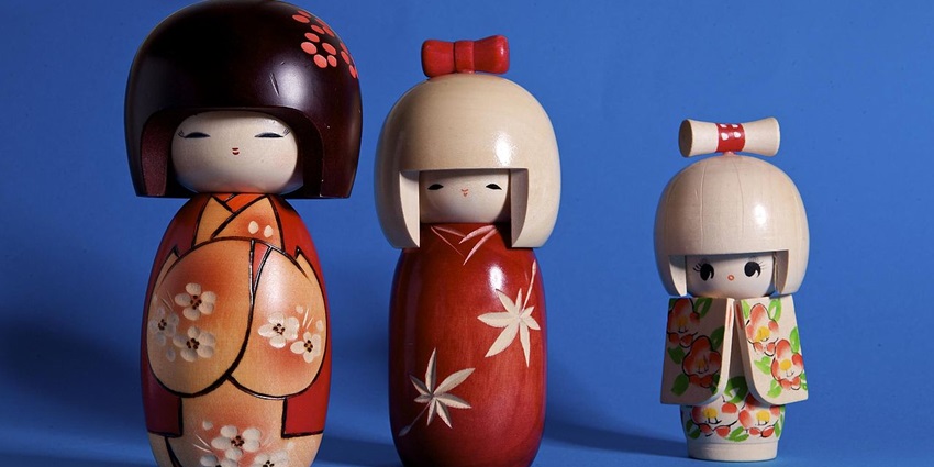 Hand-painted wooden Kokeshi dolls with bright colours and floral designs—popular things to buy in Tokyo.