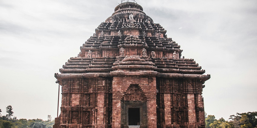 A serene view of Konark Sun Temple with traditional architecture, intricate carvings.