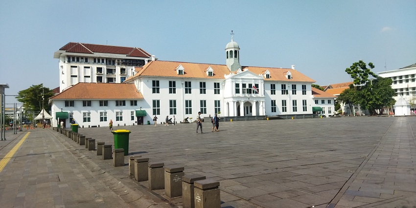 A large colonial-era white building with an orange roof at Fatahillah Square, one of the top historical places in Indonesia.