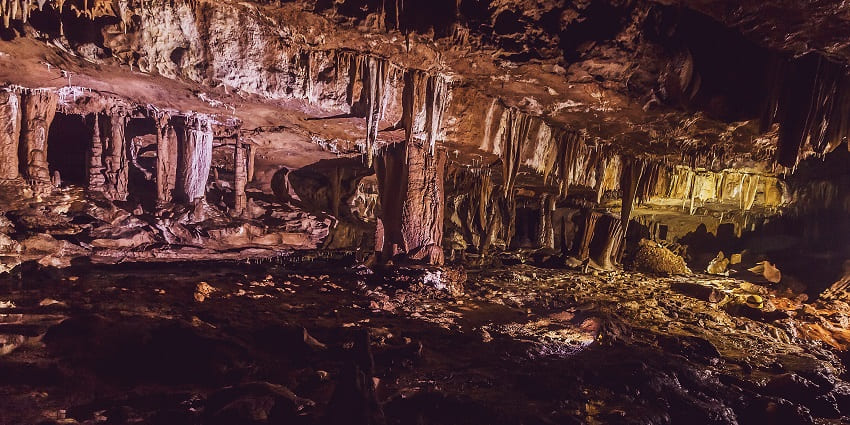 Caves in Meghalaya with unique stone formations and cavemen wearing a helmet torch.