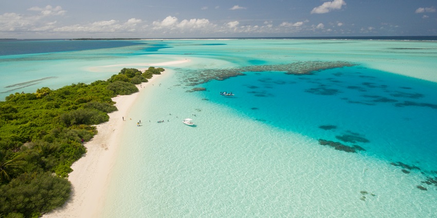 Kudahuvadhoo from above with sandy shore of a beach and a boat in the sea