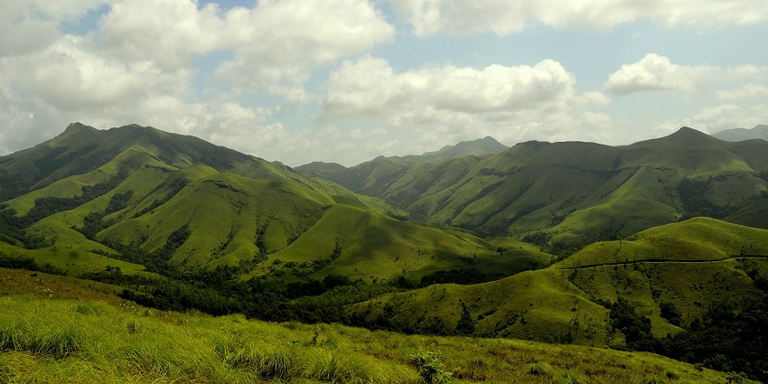 Scenic rolling hills and open grassland set against a misty cloud, one of the places to visit in Karnataka in November.