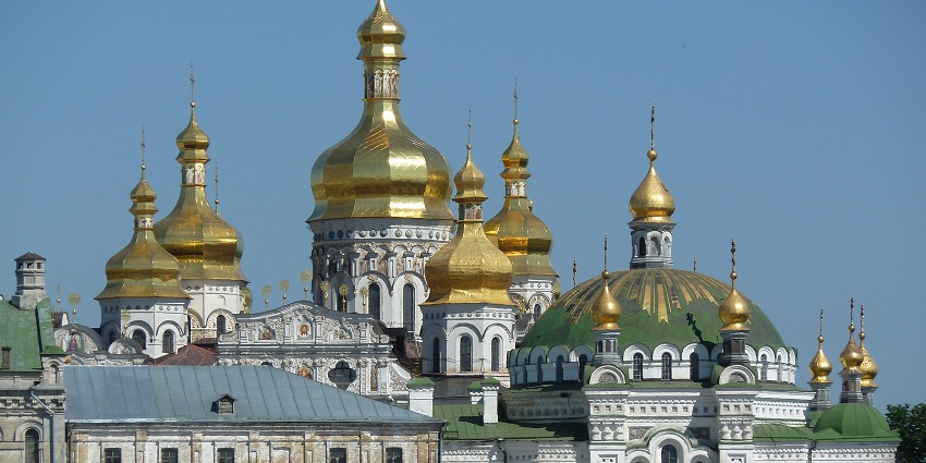Historic Kyiv-Pechersk Lavra monastery with golden domes and historic church buildings.
