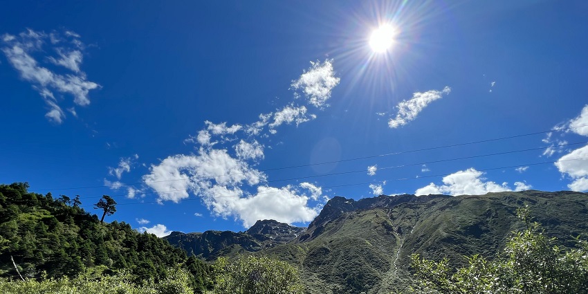 Misty Yumthang Valley with lush green meadows, flowing river, and surrounding mountains