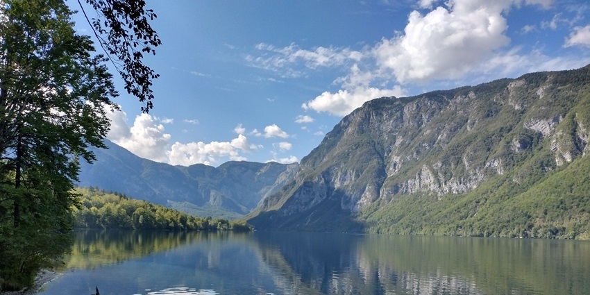 A cinematic view of Lake Bohinj in Slovenia, surrounded by mesmerising mountains.