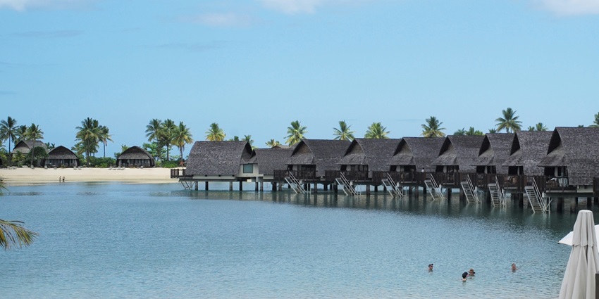 Luxury beachfront villas and lush coconut plantations set against turquoise lagoons.