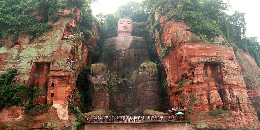 A giant stone Buddha is carved into a cliff overlooking the Min River, China's monuments