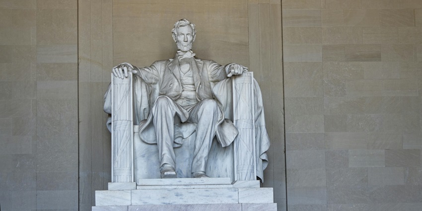 A seated marble statue of Abraham Lincoln inside a neoclassical temple monument in the USA