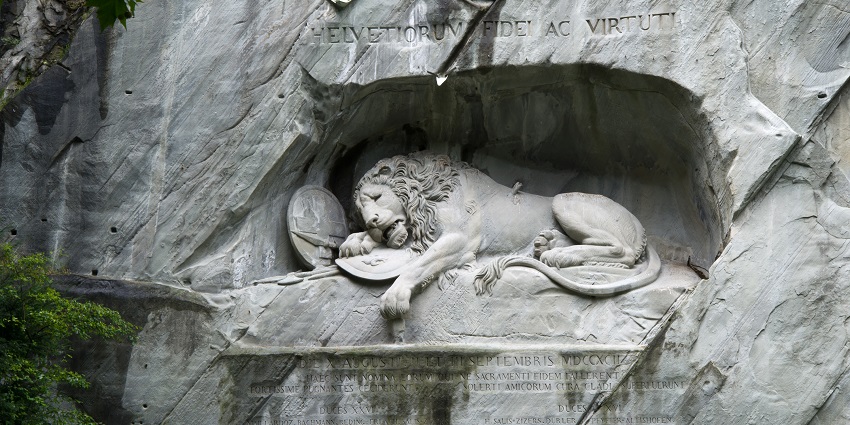 The Lion Monument in Lucerne is among the famous monuments in Switzerland, depicting a dying lion carved in stone, surrounded by a rocky wall.