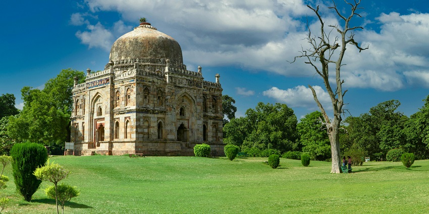 Lodhi Garden with traditional Islamic building surrounded by lush greenery.