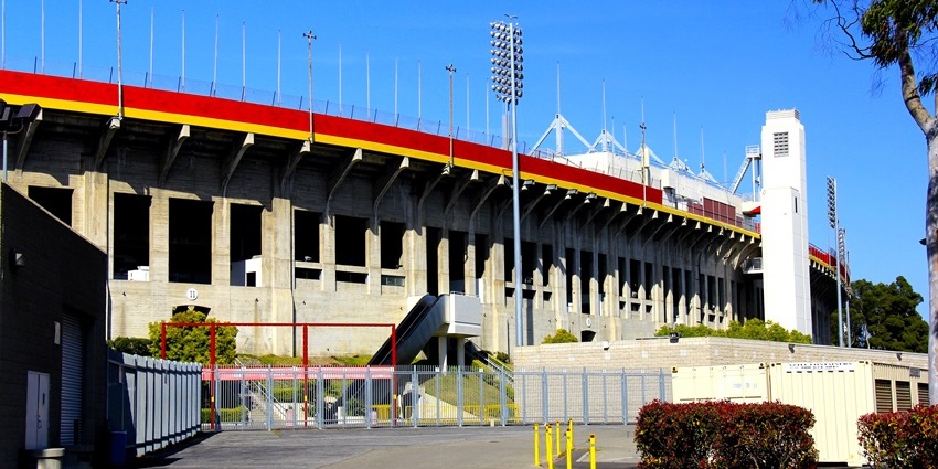 Los Angeles Memorial Coliseum with an escalator, stairs, an entrance gate, and stadium lights