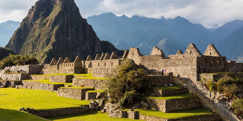 Machu Picchu in the Andes Mountains, a famous monument in Peru, is under a clear sky.