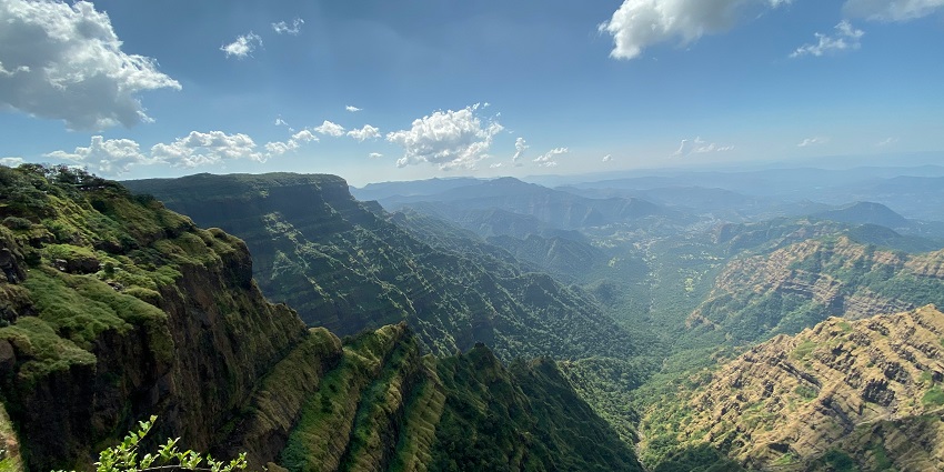 Tourists enjoying mountain views from a viewpoint near Pune, a popular summer retreat.