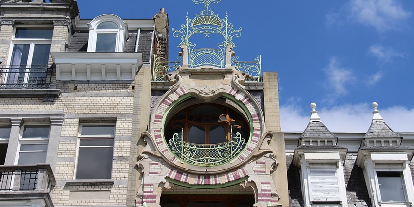 Facade of Maison Saint-Cyr with a uniquely designed circular window and a cross on the top, one of the most beautiful hidden places Brussels.