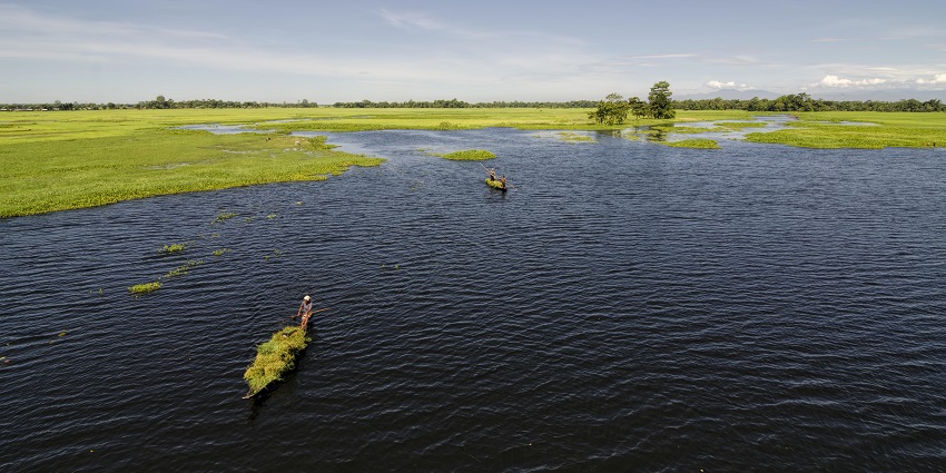 Majuli Island, with boats floating on the blue waters of the river, is one of the places to visit in Assam in November.
