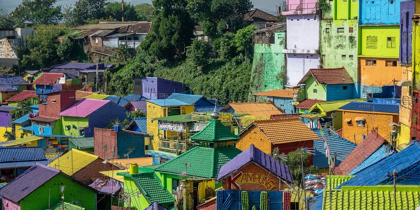 Scenic view of Malang with colonial buildings and surrounding green hills.