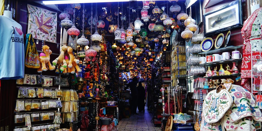 Colorful market stalls fill the narrow lanes of Manama Souq, bustling with traditional goods and local charm.