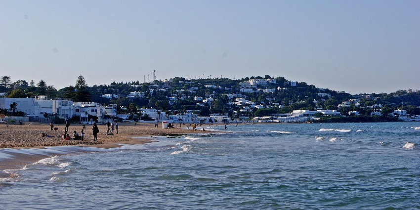 Marsa Beach in the distance, revealing a tranquil Mediterranean shore with soft waves and clear skies.