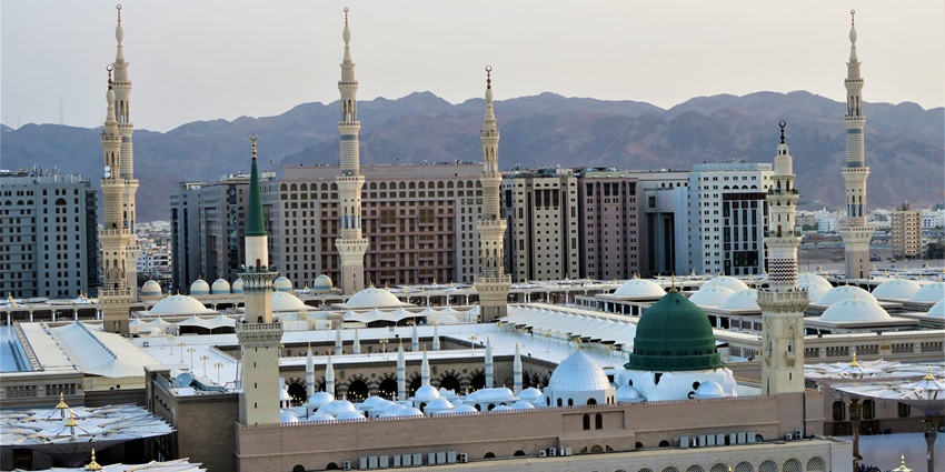 An image of the view of the Masjid An-Nabawi, with thousands of worshippers.