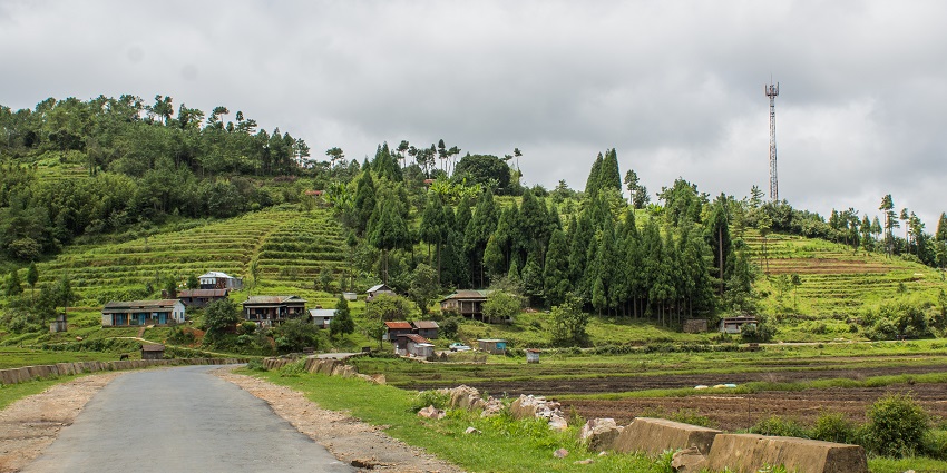 Mawsynram in Meghalaya with water falling into the small lake and lush greenery.
