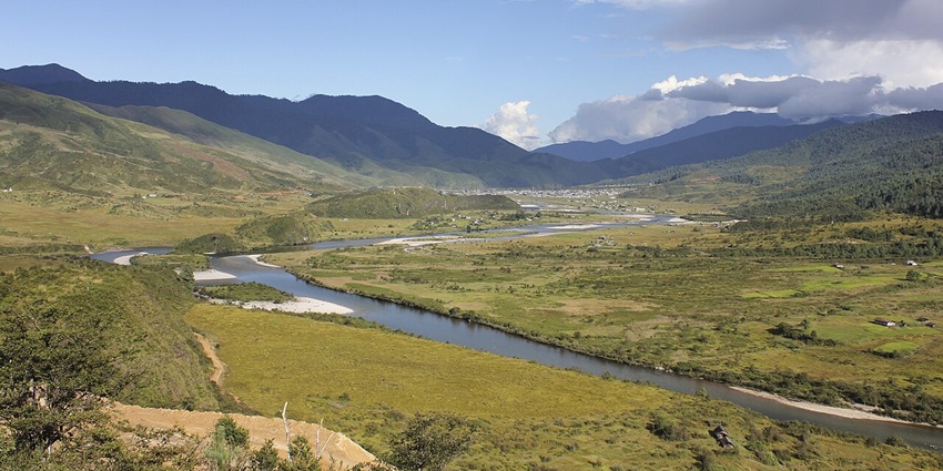 Mechuka with a water body of a river flowing and green plains surrounded by mountains