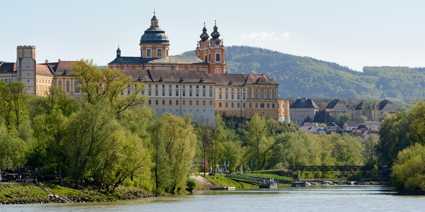 Melk Abbey in Austria, a large historic monastery with golden yellow buildings overlooking the Danube River, one of the top historical places in Austria.
