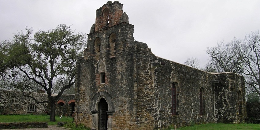 Mission Espada in San Francisco with an old ruined building and a Christian cross on the ground