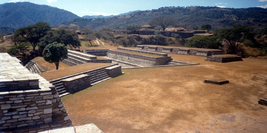 Fortified green hilltop ruins of Mixco Viejo surrounded by valleys.