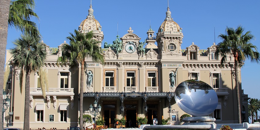 Monte Carlo casino with multiple detailed carvings, and statues on top of the entrance