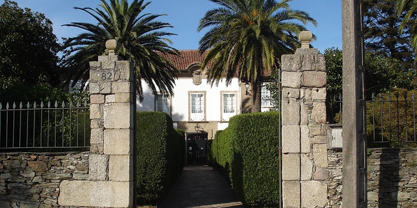 Entrance to the Monte Cecilia house with a small trail leading to the house and palm trees