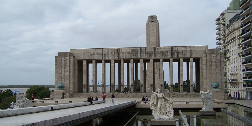 Monumento a la Bandera with multiple statues, traditional architecture and people exploring