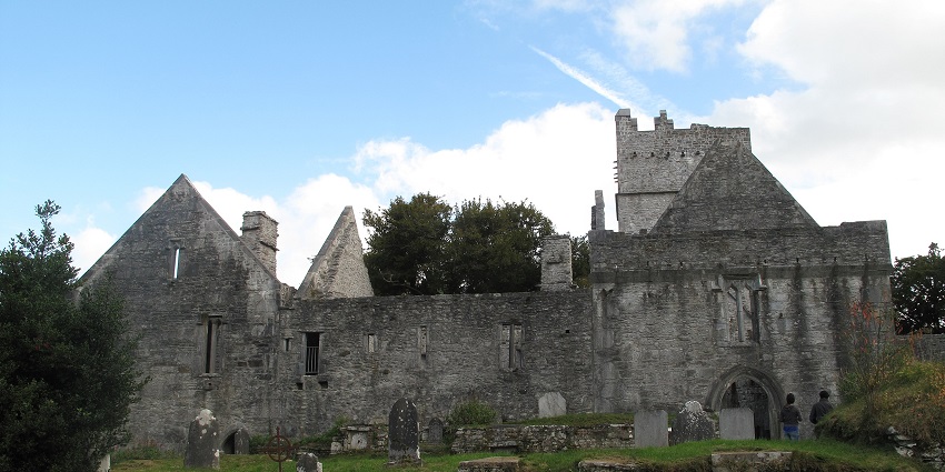 Ruins of Muckross Abbey surrounded by greenery, showcasing medieval Irish architecture