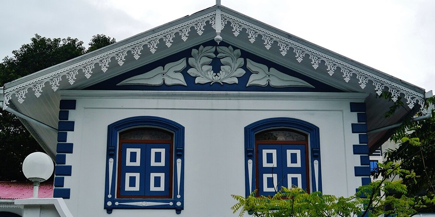 Facade of Mulee’aage palace with blue & white architecture, sphere lamp and a small tree