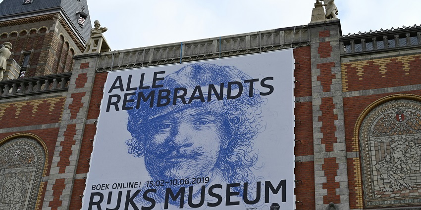 Large mural displayed on the side of a city building with vibrant artistic detail