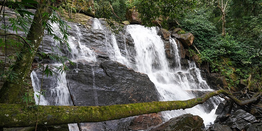 Waterfalls flow over rocky cliffs, surrounded by greenery in Pearl Valley, Karnataka, India, creating a breathtaking natural spectacle.