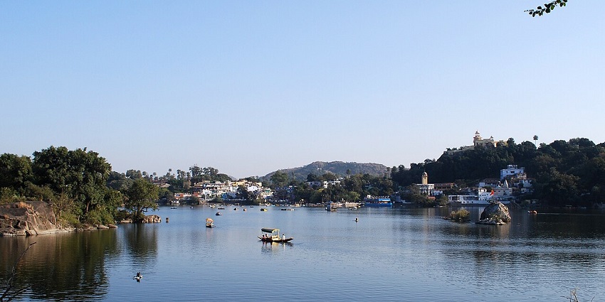 Boat on Nakki Lake with surrounding hills and clear skies in the background.