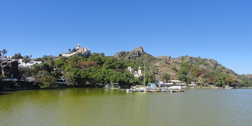 Scenic view of Nakki Lake, among the best places to visit in Mount Abu in October, surrounded by hills and boats gently floating on calm waters.