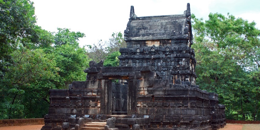 Nalanda Gedige stone temple surrounded by trees and green hills, one of the historical places in Dambulla.