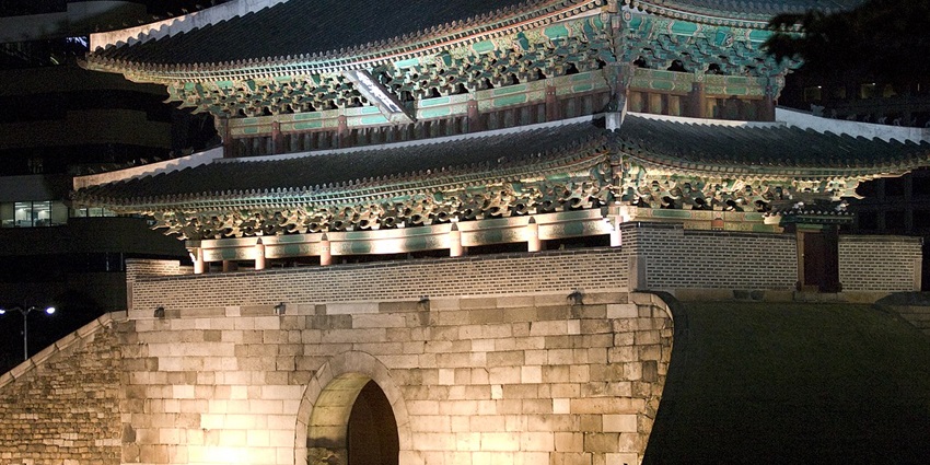 Sungnyemun Gate in Seoul is illuminated at night, and its traditional Korean architecture