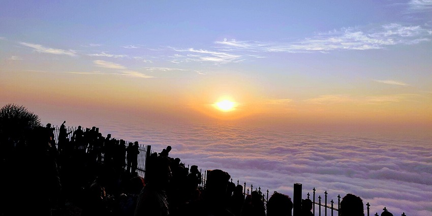 Scenic view of Nandi Hills near Bengaluru, with thick greenery, rolling hills, and misty skies creating a peaceful atmosphere.