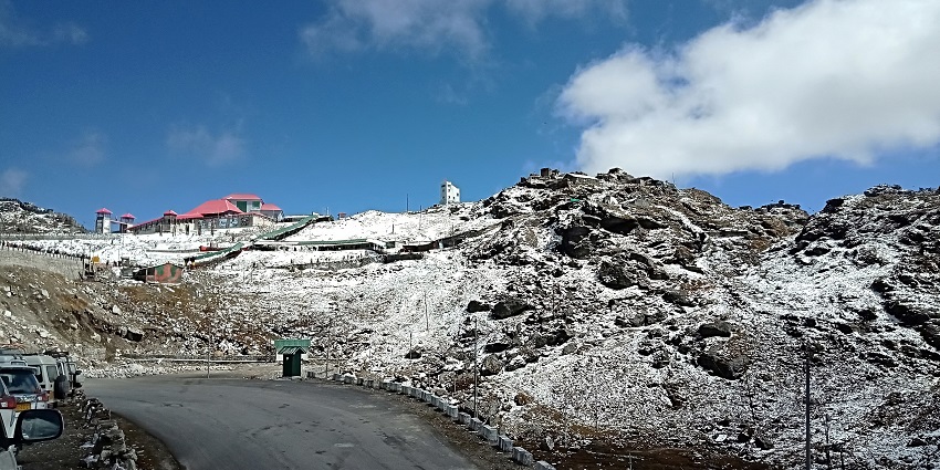 Clear view of Nathula Pass with winding mountain road and rugged, rocky terrain.