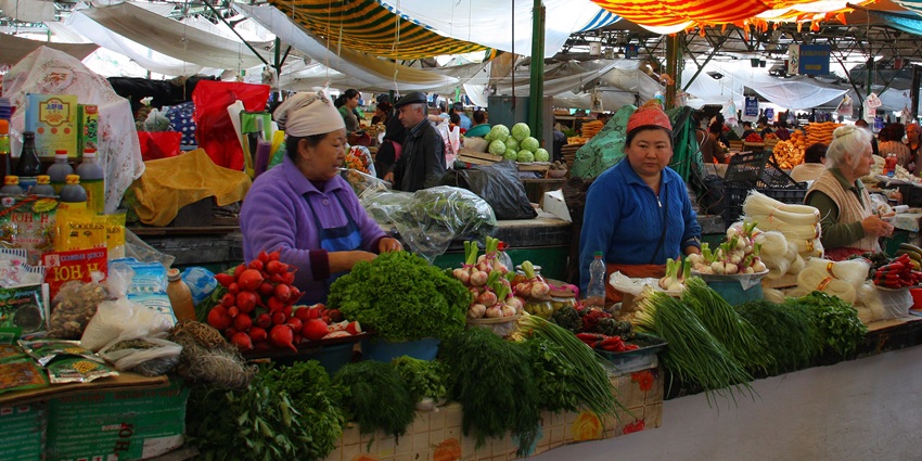 Local vendors selling fresh produce and spices at Osh Bazaar, Bishkek.